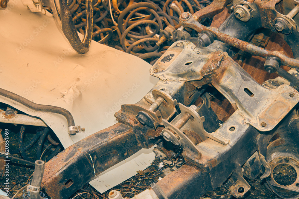 Old Car Chassis and Coil Spring and Ball Joint Set and Hose on Ground. Waste Material from Garage in Vintage Tone Old Car Chassis and Coil Spring and Ball Joint Set and Hose on Ground. Waste Material from Garage in Vintage Tone