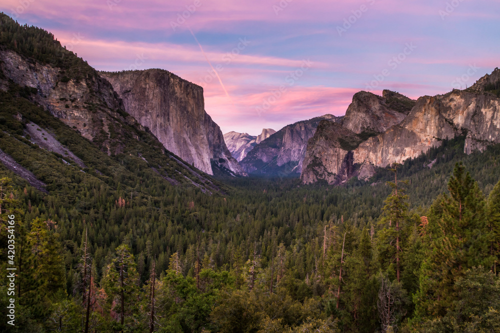 pinkish hue of the sky after sunset in Tunnel View  in Yosemite during summer. From this vantage point you can see the El Capitan and Half Dome.