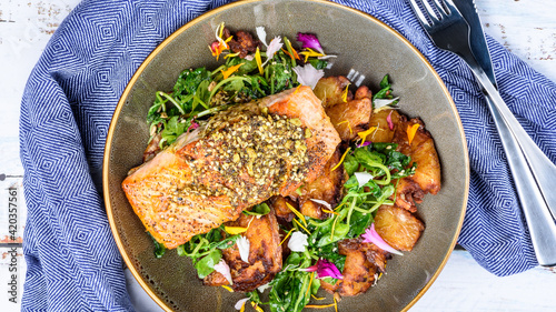 Grilled salmon served with crispy chat potatoes, snow pea tendrils and dukkah butter photo