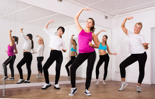 Women dancing aerobics at lesson in the dance class. High quality photo