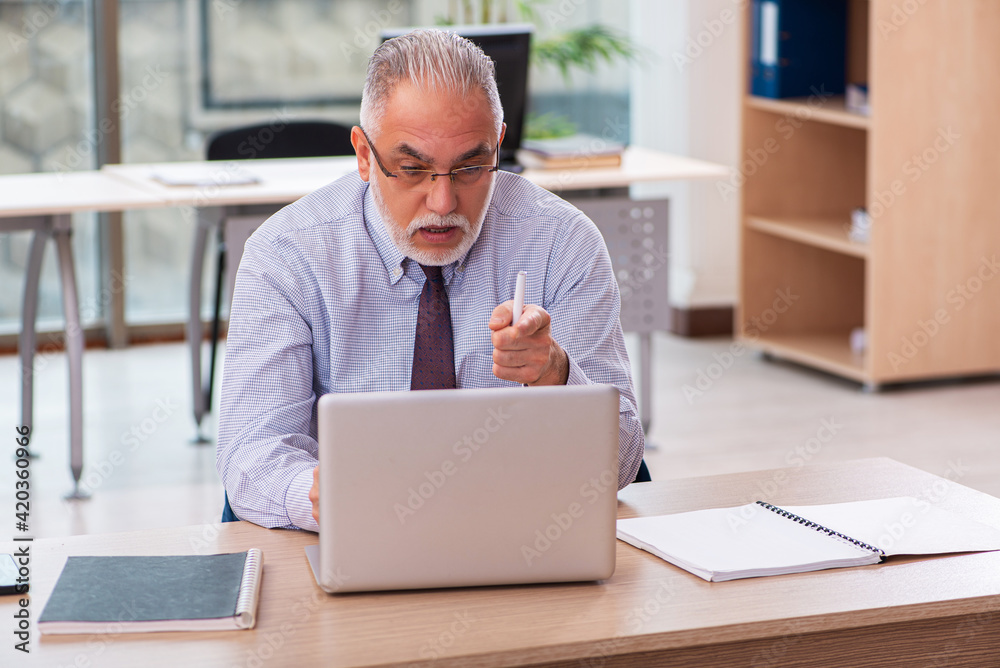 Old male boss employee working in the office Old male boss employee working in the office