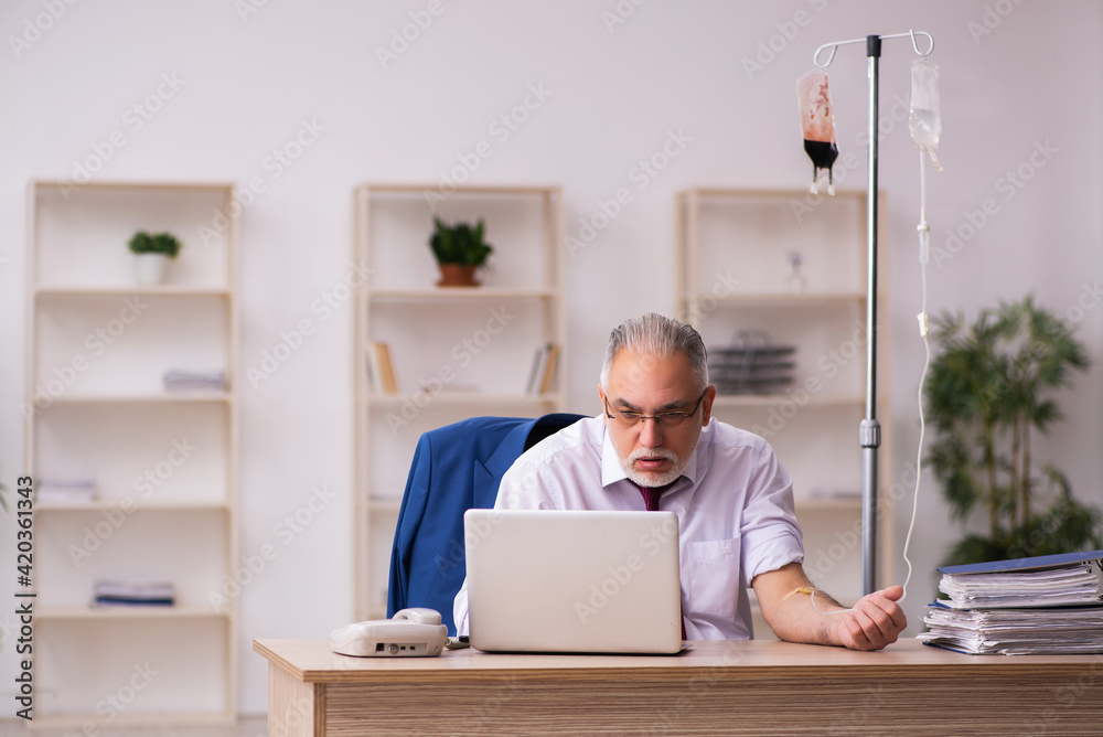 Fototapeta premium Old male employee in blood transfusion concept
