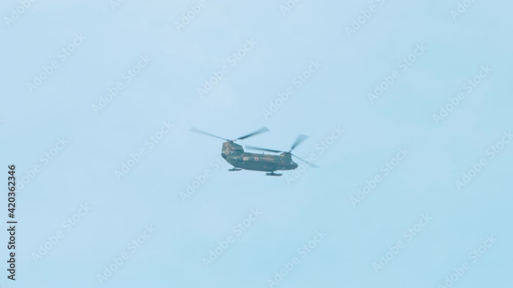 Japan Air Self-Defense Force Tandem Rotor Helicopter Flying In The Sky At Daytime. - wide shot Japan Air Self-Defense Force Tandem Rotor Helicopter Flying In The Sky At Daytime. - wide shot