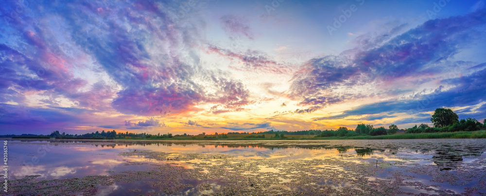 Panorama with beautiful colorful sunrise over lake