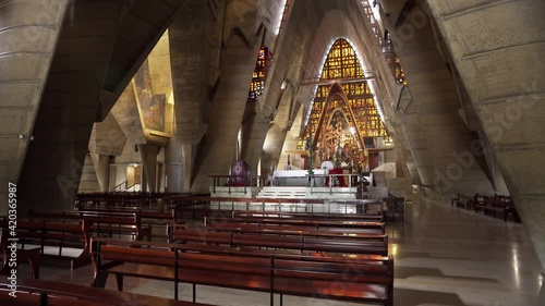 The interior of an old Christian church in the Dominican Republic. Altar and wooden benches for parishioners. Solemn atmosphere of the temple. Antique stained glass windows. Faith and repentance. photo