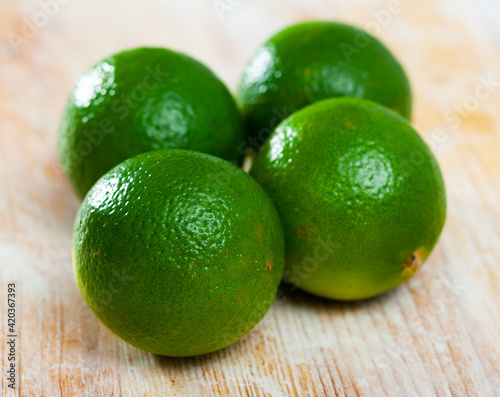 Image of fresh limes on wooden surface in home kitchen  nobody