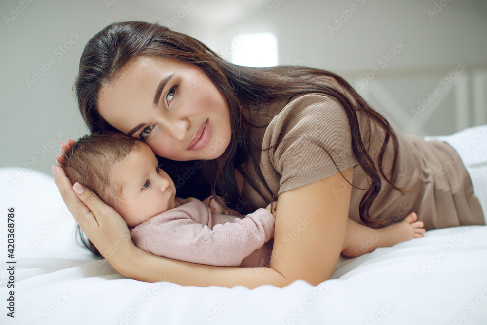 A young mother is holding her newborn baby. Mother of a nursing baby. Mother breastfeeding her baby. The family is at home. Portrait of a happy mother and child. High quality photo. A young mother is holding her newborn baby. Mother of a nursing baby. Mother breastfeeding her baby. The family is at home. Portrait of a happy mother and child. High quality photo.