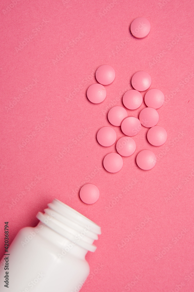 Open jar with pills on pink background coldspace top view Open jar with pills on pink background coldspace top view