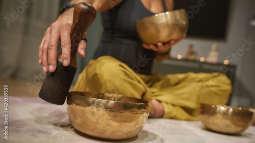 Selective focus on tibetan singing bowl played by woman