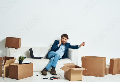 a man sitting on the couch talking on the phone an official box of things