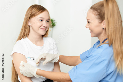 woman doctor giving a child a girl an injection in the arm covid 