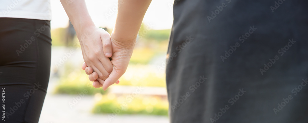 Obraz premium Header format of Senior mother walking hand in hand with daughter in green park during summer time, concept of family love and care, mother day, family day, mom and daughter togetherness in summer