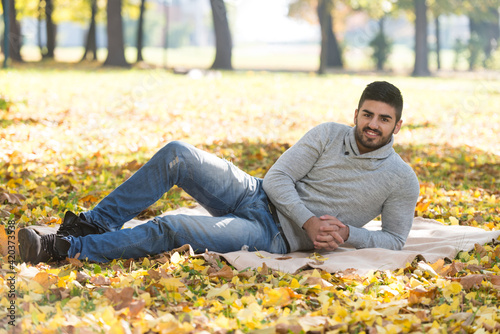 Portrait Of Handsome Young Man In Autumn Park