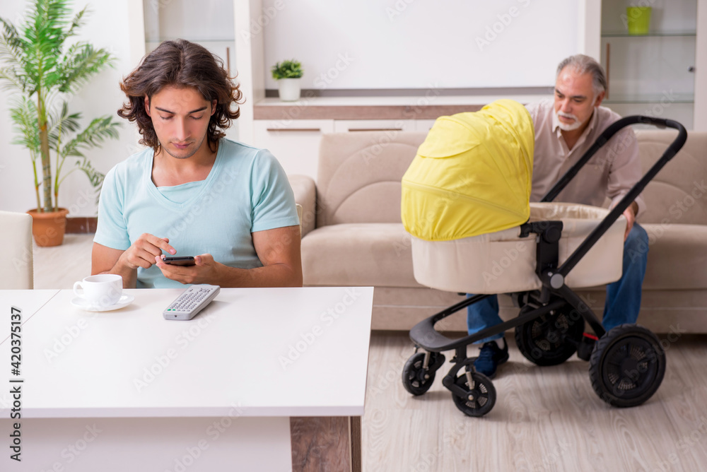 Obraz premium Retired grandfather looking after newborn at home