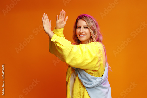 Trendy fashionable woman dancer posing against yellow backgorund