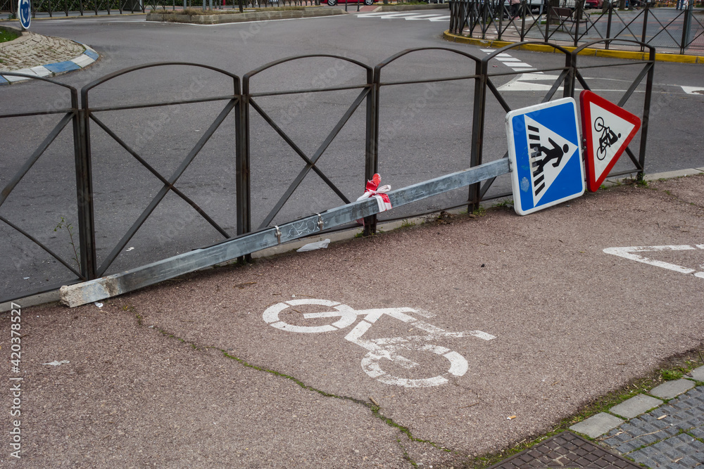 Bike path and traffic signal ripped off and lying on the ground. Bike path and traffic signal ripped off and lying on the ground.
