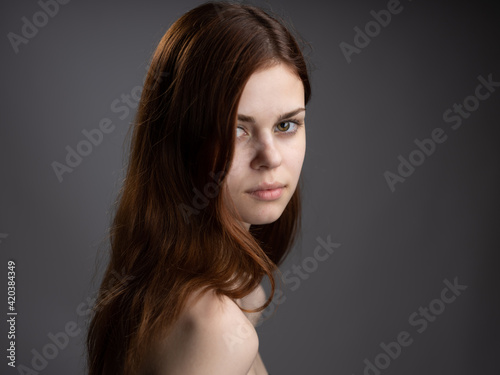 fashionable woman with red hair naked shoulders side view
