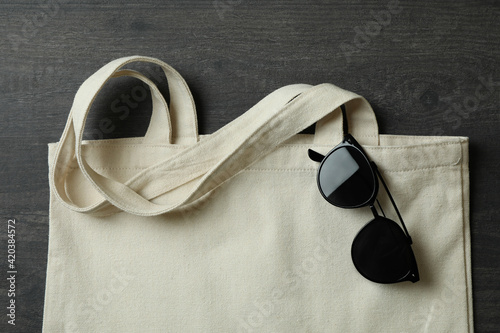 Eco bag with sunglasses on dark textured background
