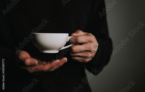 Mug of coffee close up in male hands.