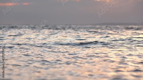 Low angle shoot waves foam in focus and the colorful sunset sky background photo