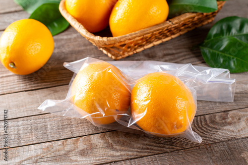Fresh ripe lemons in a freezer bag on a wooden table