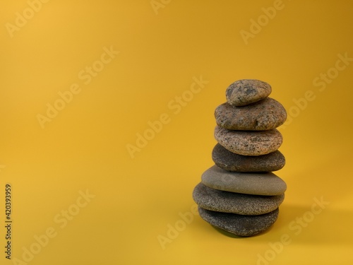 pebble stones form a pyramid on a yellow background