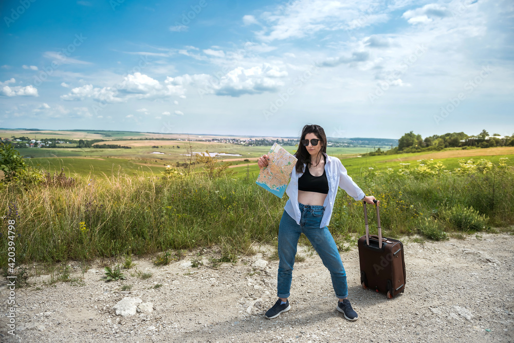 Fototapeta premium Pretty young woman stand and look at the map on the road, enjoy summer vacation