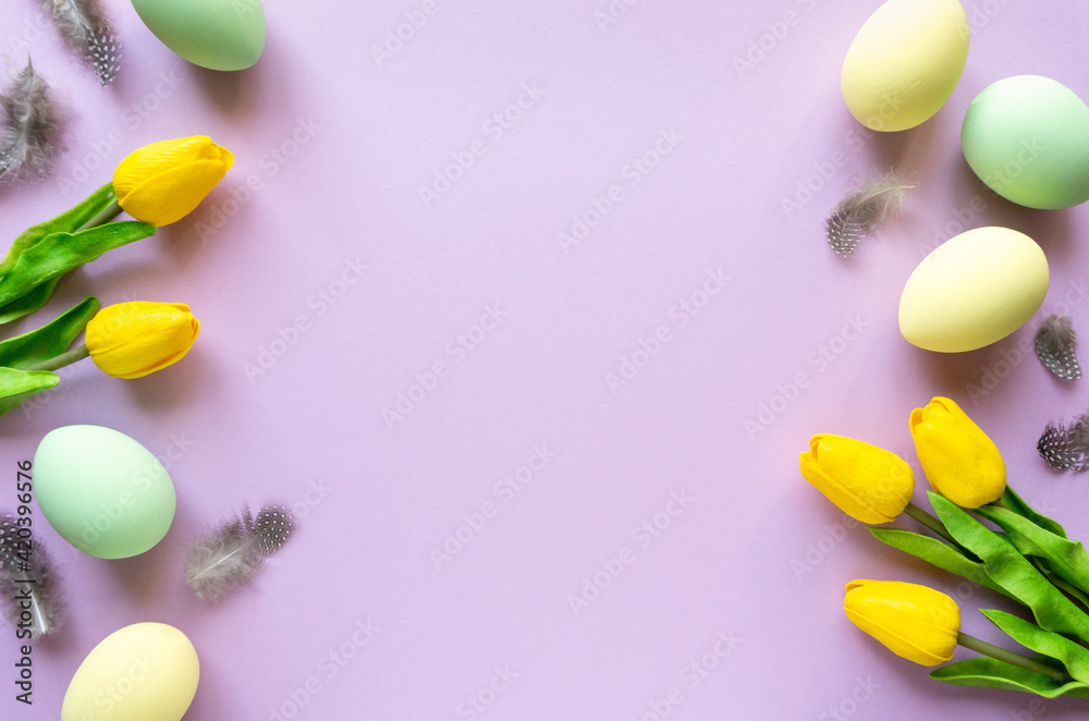 Easter flat lay. Painted eggs with tulips and feathers on lilac background, space for text