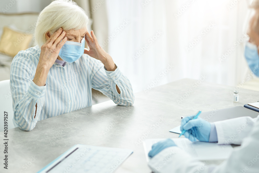Sick old woman discussing health problems with doctor in clinic Sick old woman discussing health problems with doctor in clinic