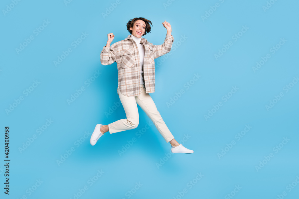 Profile full size photo of optimistic funny lady jump wear shirt trousers sneakers isolated on teal color background Profile full size photo of optimistic funny lady jump wear shirt trousers sneakers isolated on teal color background