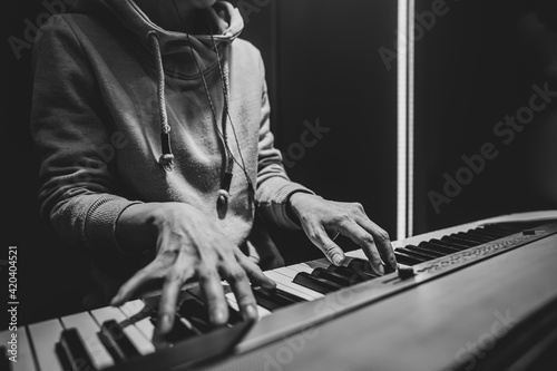 A woman plays the musical keys in the studio close up.