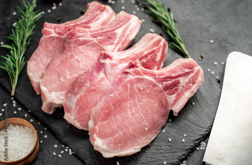 raw pork steaks on stone background