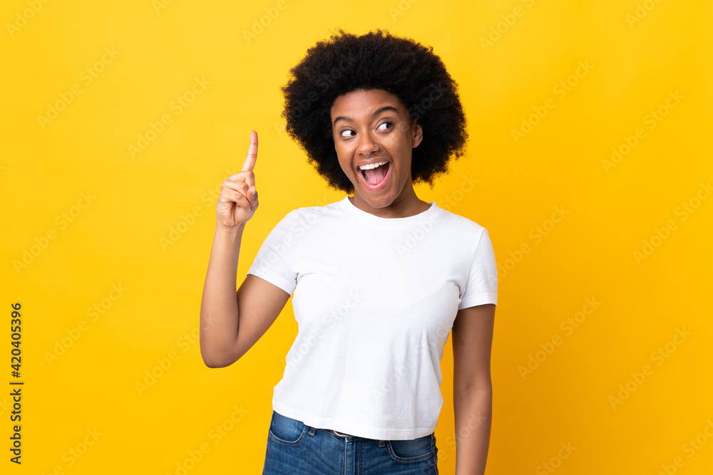 Young African American woman isolated on yellow background intending to realizes the solution while lifting a finger up