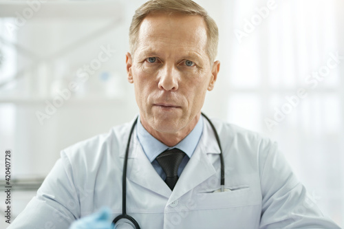 Good-looking male doctor posing against white background
