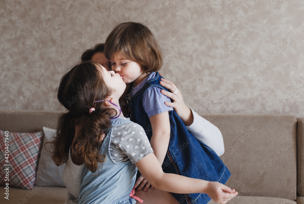 two little girls kiss each other on the lips while sitting on their
