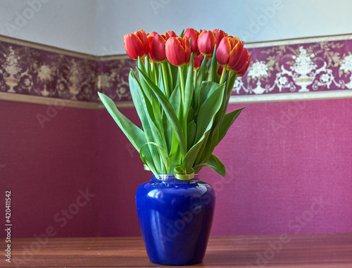 Red Tulips. Bud, petals, bouquet.Red tulips in a decorative vase stand on a table. Russia, Moscow, holiday, gift, mood, nature, flower, plant, bouquet, macro