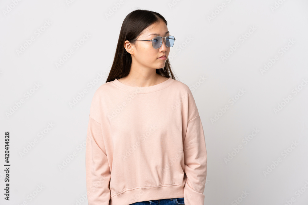 Young Chinese girl over isolated white background looking to the side Young Chinese girl over isolated white background looking to the side