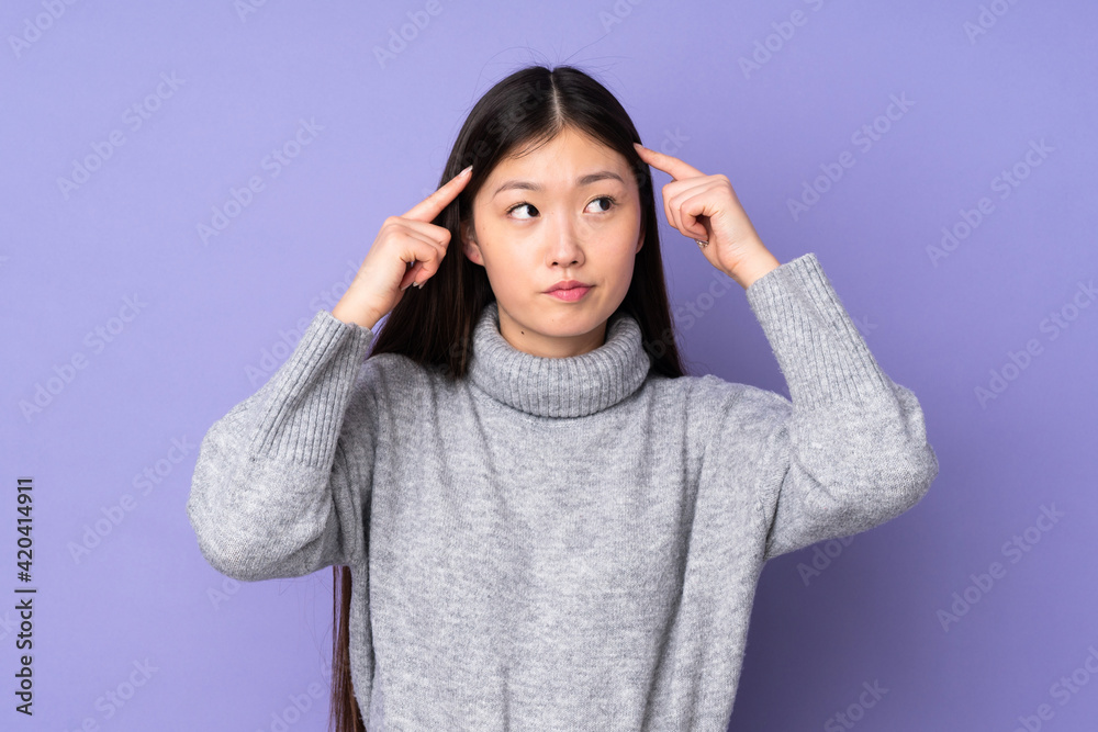 Young asian woman over isolated background having doubts and thinking Young asian woman over isolated background having doubts and thinking