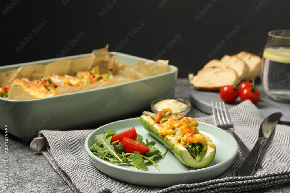 Baked stuffed zucchinis served on grey table