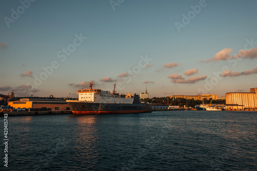 Cargo ship in sea and buildings on coast of Istanbul during sunset, Turkey
