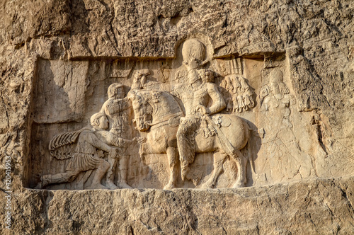 A relief depicting the triumph of Shapur the Great, the second King of Kings of the Sasanian empire, over the Roman emperors Valerian and Philip the Arab located at Naqsh-e Rostam necropolis in Iran photo