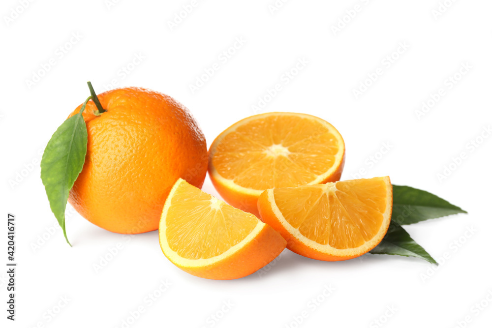 Cut and whole fresh ripe oranges with green leaves on white background Cut and whole fresh ripe oranges with green leaves on white background