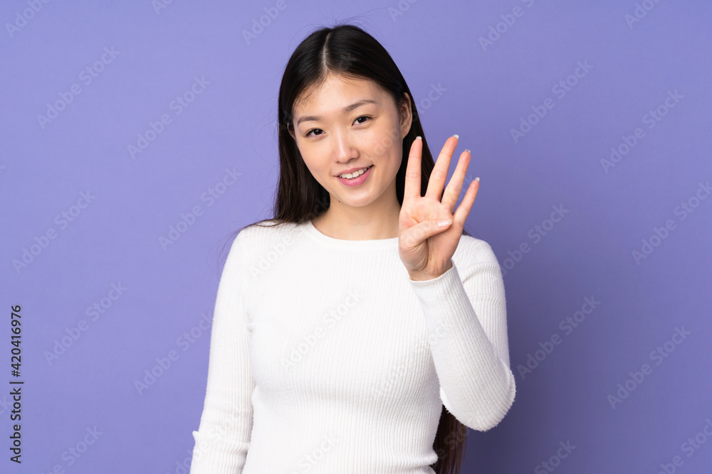 Young asian woman isolated on purple background happy and counting four with fingers Young asian woman isolated on purple background happy and counting four with fingers