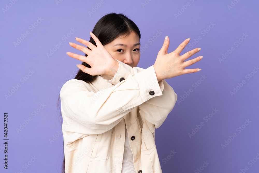 Young asian woman isolated on purple background nervous stretching hands to the front Young asian woman isolated on purple background nervous stretching hands to the front