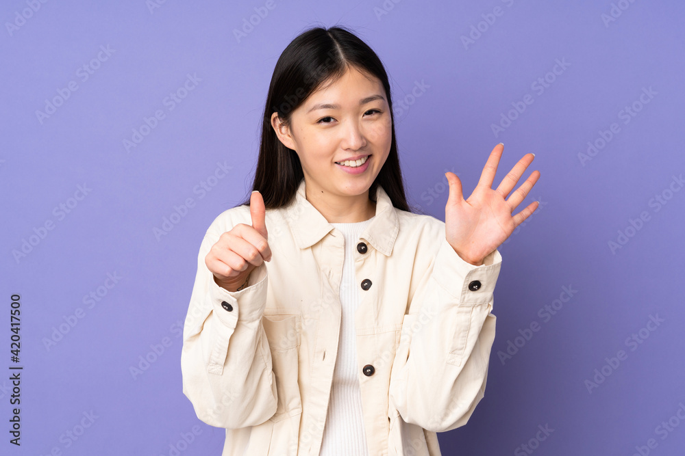 Young asian woman isolated on purple background counting six with fingers Young asian woman isolated on purple background counting six with fingers