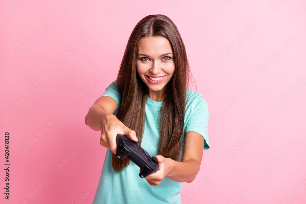 Photo of young beautiful happy smiling positive cheerful woman playing video games with joystick isolated on pink color background Photo of young beautiful happy smiling positive cheerful woman playing video games with joystick isolated on pink color background