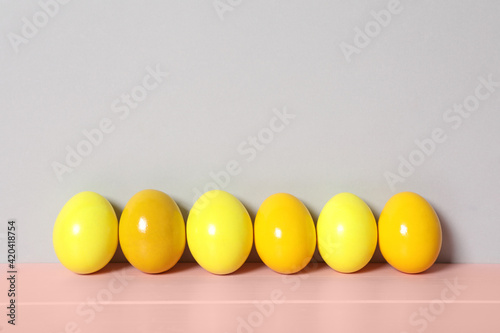 Easter eggs on pink wooden table against light grey background, space for text
