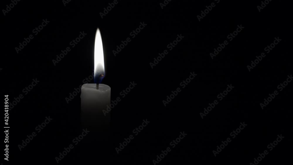 White candle on a black background White candle on a black background