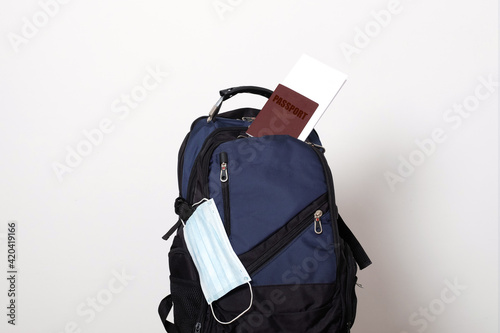 Travel backpack, passport, air ticket and mask. Travel ban during the pandemic of coronavirus or covid-19.