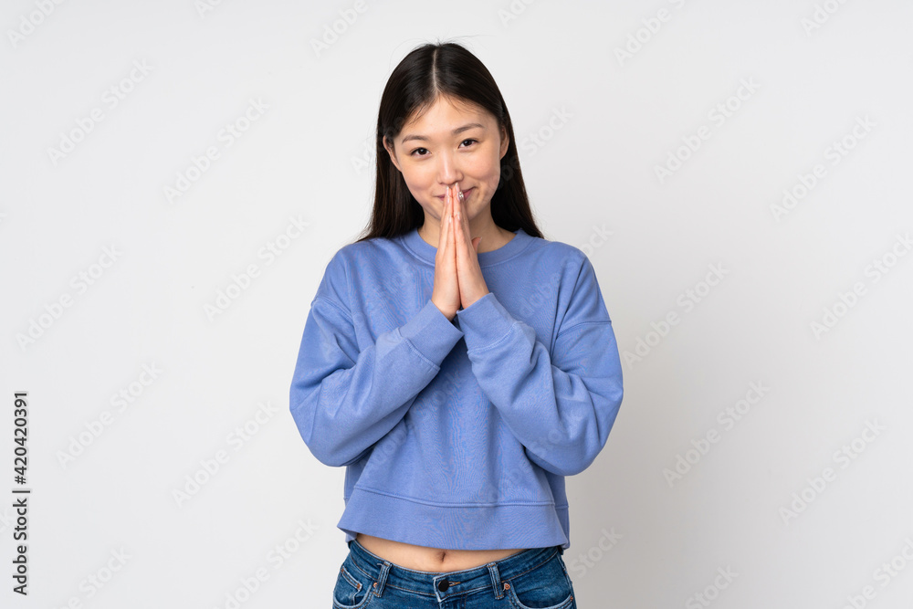 Young asian woman isolated on background keeps palm together. Person asks for something Young asian woman isolated on background keeps palm together. Person asks for something